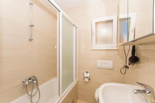 y baño con ducha, lavabo y bañera. en Apartments Vukman, en Trogir