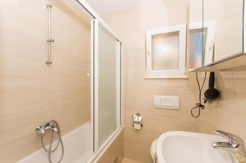 ein Badezimmer mit Dusche, Waschbecken und Badewanne in der Unterkunft Apartments Vukman in Trogir