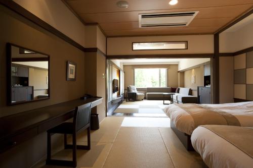 a hotel room with two beds and a mirror at Lake Shikotsu Tsuruga Resort Spa Mizu no Uta in Chitose