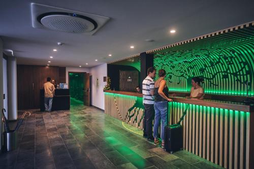 a group of people standing at a green bar at Hotel Cruzeiro in Angra do Heroísmo