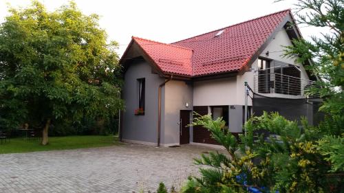 a white house with a red roof and a driveway at Rezerwat85 in Gdańsk