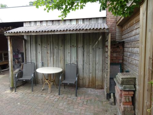 a patio with a table and chairs and a fence at B&B Mendelts in Emmen