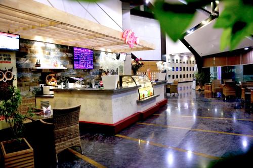 a restaurant with a counter and tables and chairs at Ana Clarks Inn, Panchkula in Panchkula