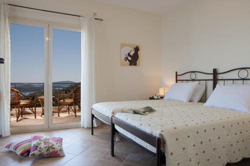 - une chambre avec un lit et un balcon dans l'établissement Villa Aeropi, à Nikiana