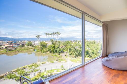 a bedroom with a large window overlooking a lake at WMS Villa in Dongshan