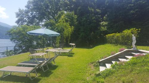 a group of tables and chairs with an umbrella at Albergo Del Lago in Cannobio