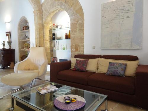 ein Wohnzimmer mit einem braunen Sofa und einem Glastisch in der Unterkunft Esglesia 10 in Alcúdia