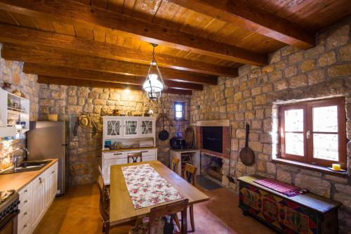 cocina con mesa y pared de piedra en Stone House Knezevic, en Vinjerac