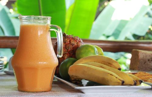 a glass of orange juice next to a plate of fruit at Casa de Palos Boutique in Tarapoto