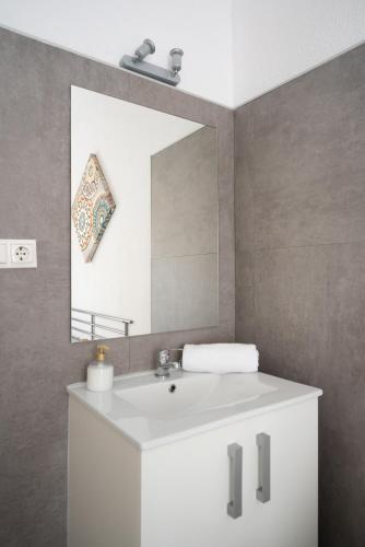 a bathroom with a white sink and a mirror at Pension Venecia Gomerez in Granada