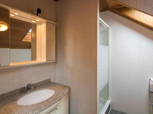 a bathroom with a sink and a mirror at Modern holiday home with swimming pool in Saint-Nexans