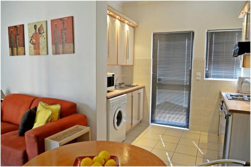 a small living room with a couch and a kitchen at Chala-Kigi Apartments in Swakopmund
