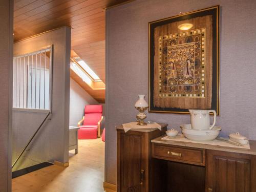 a hallway with a painting and a table with a vase at Modern holiday home with swimming pool in Saint-Nexans