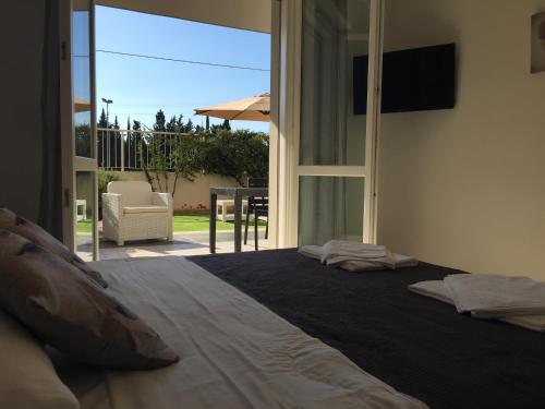 - une chambre avec un grand lit et une vue sur un patio dans l'établissement Le Domus lovely apartment, à Quartu SantʼElena