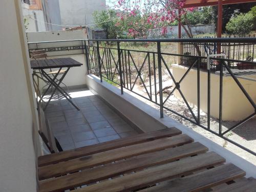 a balcony with a wooden stairs and a table at Anais apartment in Preveza