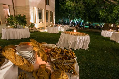 a table with plates of food on top of a field at Hotel Parco delle Fontane in Siracusa