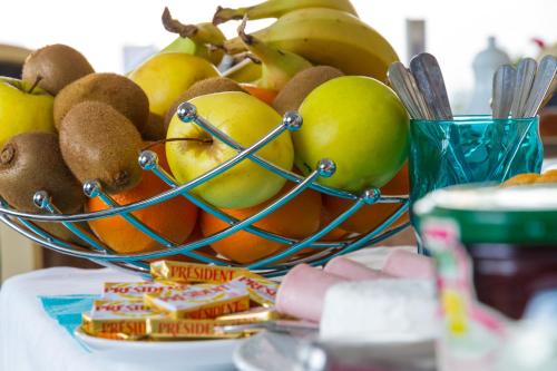 a bowl of fruit sitting on a table at Hôtel L'ideal le Mountbatten in Arromanches-les-Bains