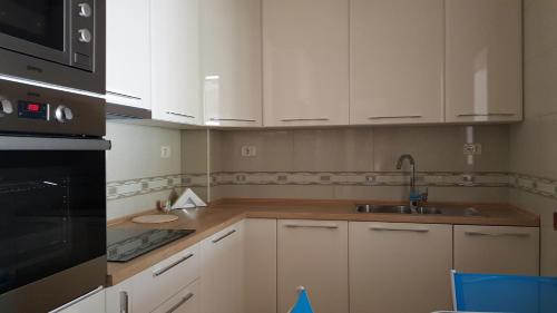 a kitchen with white cabinets and a sink at Apartment Olive in Bar