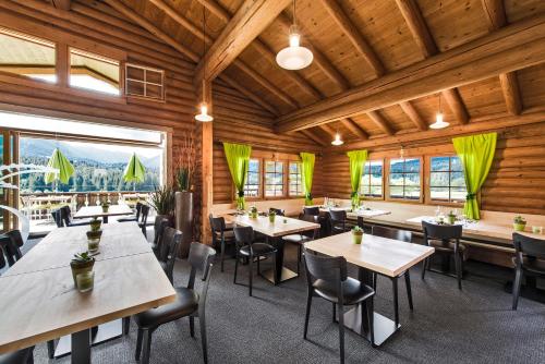 un restaurante con mesas y sillas y una gran ventana en Hotel Ustria Parlatsch, en Trin