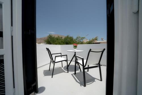 a patio with two chairs and a table on a balcony at Divelia Hotel in Perissa