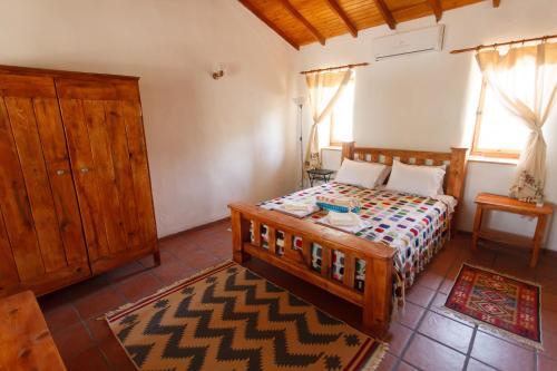 Schlafzimmer mit einem Holzbett und einem Holzschrank in der Unterkunft Ionia Guest House in Aydın