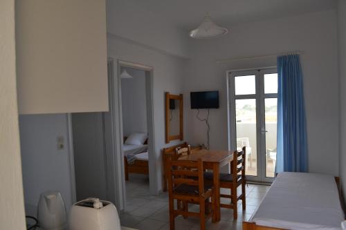 a room with a table and a room with a bed at Asteri apartments in Malia