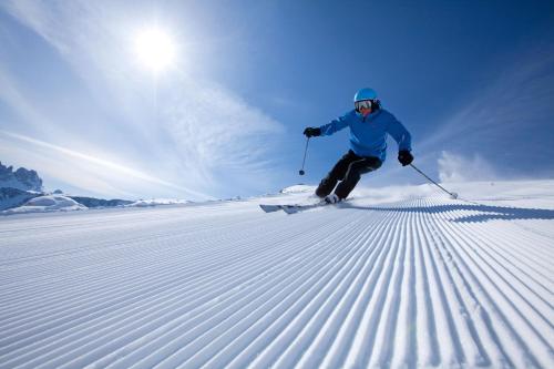 a person is skiing down a snow covered slope at Hotel ANDER in Brunico