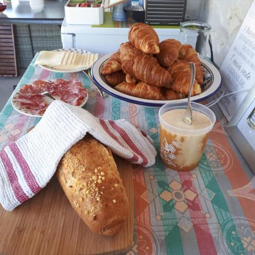 a table with a plate of pastries and a cup of coffee at Gîte et chambres d'hôtes Le Chêne Billault in Pouant
