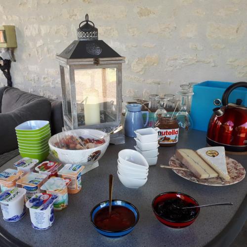 a table topped with bowls and plates of food at Gîte et chambres d'hôtes Le Chêne Billault in Pouant