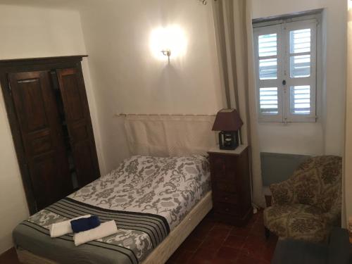 a small bedroom with a bed and a chair at Chambres A Casa De Giovanni à Pietra-di-Verde en Haute-Corse in Pietra-di-Verde