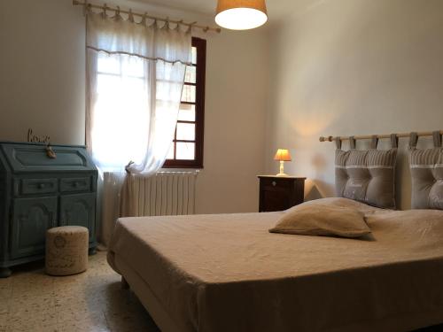 une chambre avec un grand lit et une fenêtre dans l'établissement Villa Domélia, à Villelaure