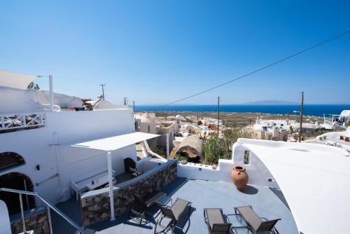 a balcony with chairs and a view of the ocean at Caves 1880 in Oia