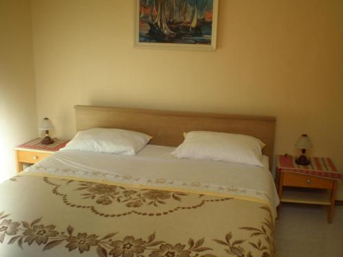 a bedroom with a large bed with two night stands at Tivoli Apartment in Ičići