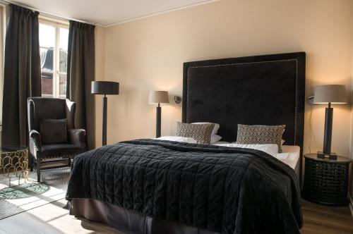 a bedroom with a large bed and a chair at Statt Hassleholm BW Signature Collection in Hässleholm