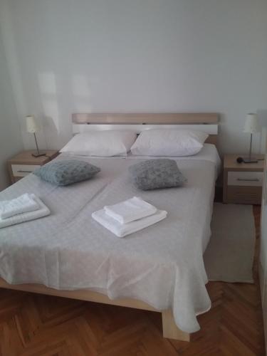 a bed with two towels and two pillows on it at MILDA+M in Skradin