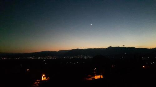 a view of a city at night with the moon at La Petite Planete in Mykines