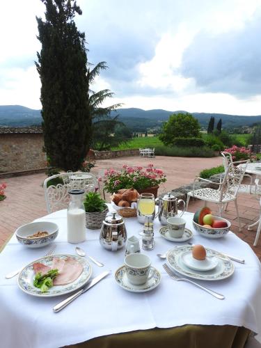ein Tisch mit einer weißen Tischdecke und Essen darauf in der Unterkunft Relais Borgo Di Toiano in Sovicille
