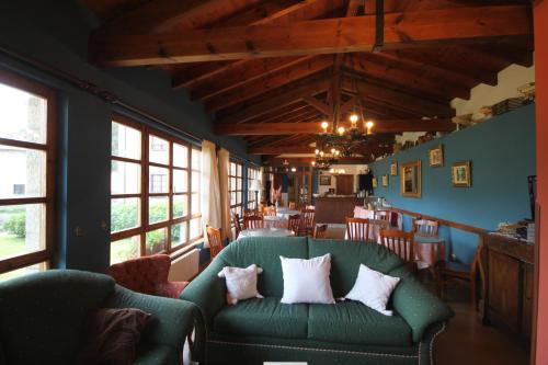 ein Wohnzimmer mit einer grünen Couch mit Kissen darauf in der Unterkunft Hotel Rural Ovio in Nueva de Llanes