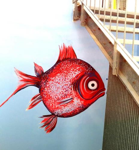 a red fish painted on the side of a wall at L'Angolo Di Beppe in Torre Lapillo