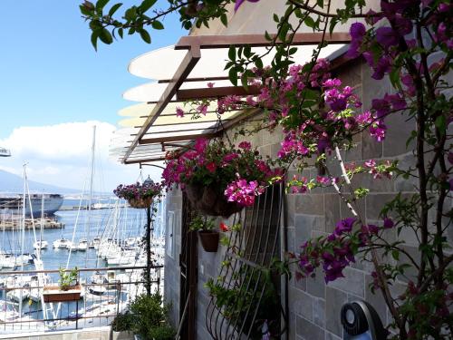 a building with flowers on it next to a harbor at Siriana open space in Castellammare di Stabia