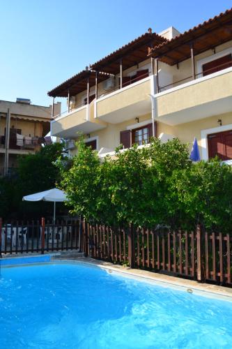 a swimming pool in front of a building at Voula Apartments in Agia Marina Aegina