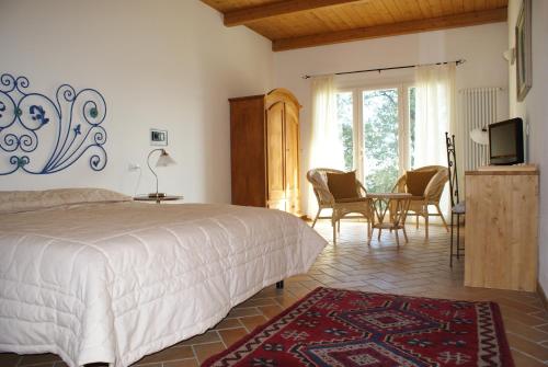 1 dormitorio con 1 cama, mesa y sillas en Agriturismo al Colle, en Bertinoro
