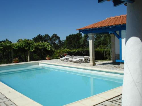a swimming pool with chairs and a gazebo at Casa Da Bela Vista in Viana do Castelo