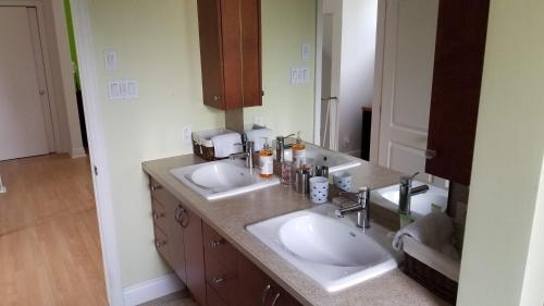 魁北克市的住宿－Appartement près des Plaines d'Abraham，一间带两个盥洗盆和大镜子的浴室