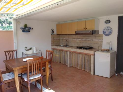 a kitchen with a wooden table and a dining room at Heart of Castellammare in Castellammare del Golfo