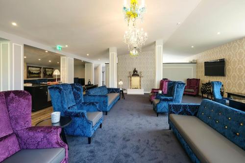 a lobby with couches and chairs and a chandelier at Hotel Rex in Bad Wiessee