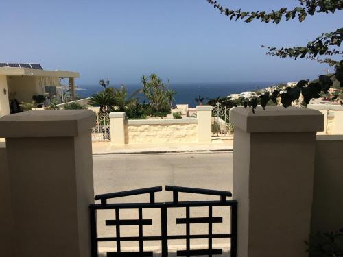 a white fence with a view of the ocean at Mellieha in Għajn Żejtuna