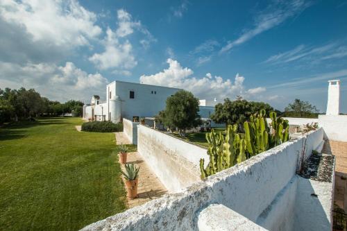 a white fence with plants on the side of a building at Masseria Borgo San Marco in Fasano