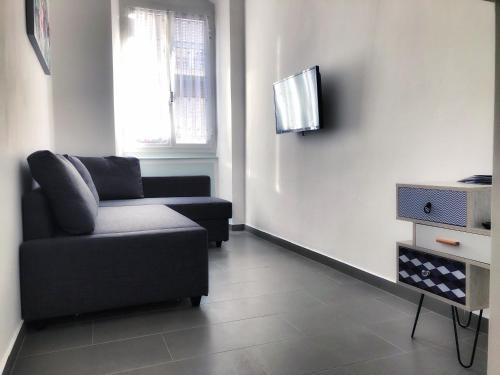 uma sala de estar com um sofá e uma televisão em Tino'S House em La Spezia