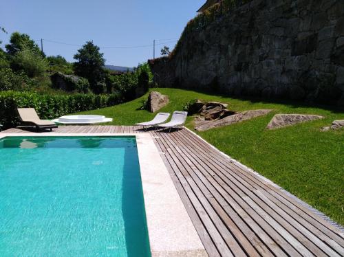 - une piscine avec 2 chaises longues à côté dans l'établissement Quinta de Alvarenga, à Alvarenga